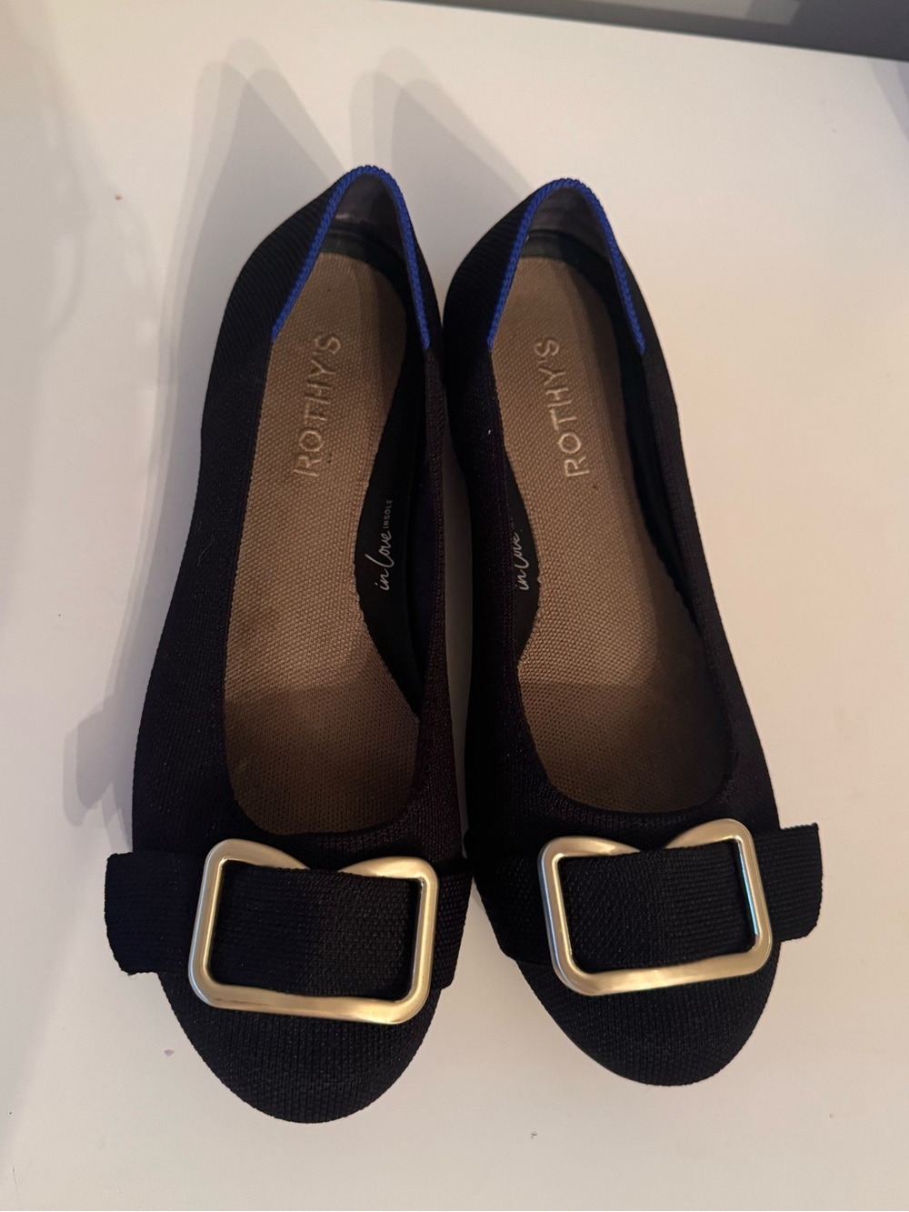 Rothy's The Emblem Black Flats with Gold Buckle and Blue Trim
